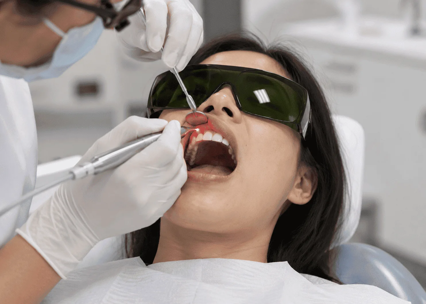 Dentist performing laser-assisted gum surgeries procedure