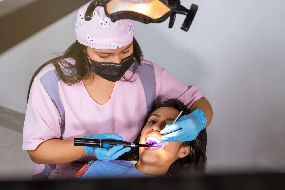 Dentist performing laser-assisted teeth whitening procedure