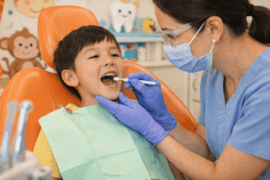 A female dentist applying dental sealant treatment to a child