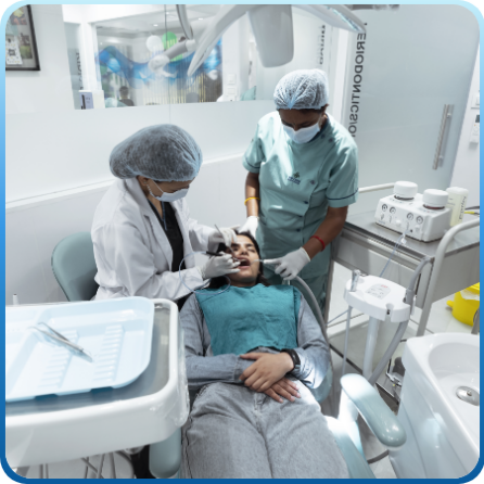 A dentist doing Preventive Dentistry on a woman and a nurse helping dentist in treatment